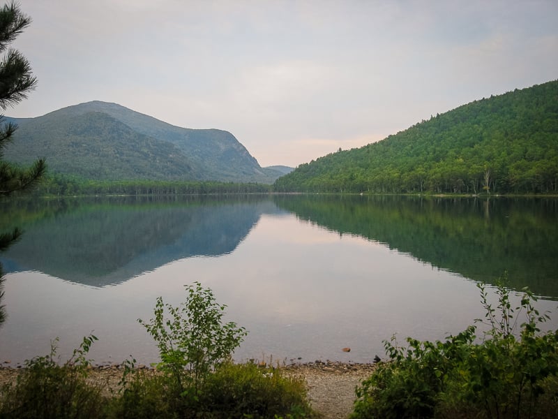 Scenic lake nestled among towering mountains and lush trees