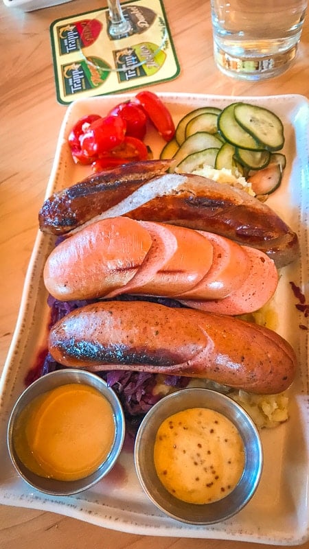 A plate of sausages, potatoes, and vegetables
