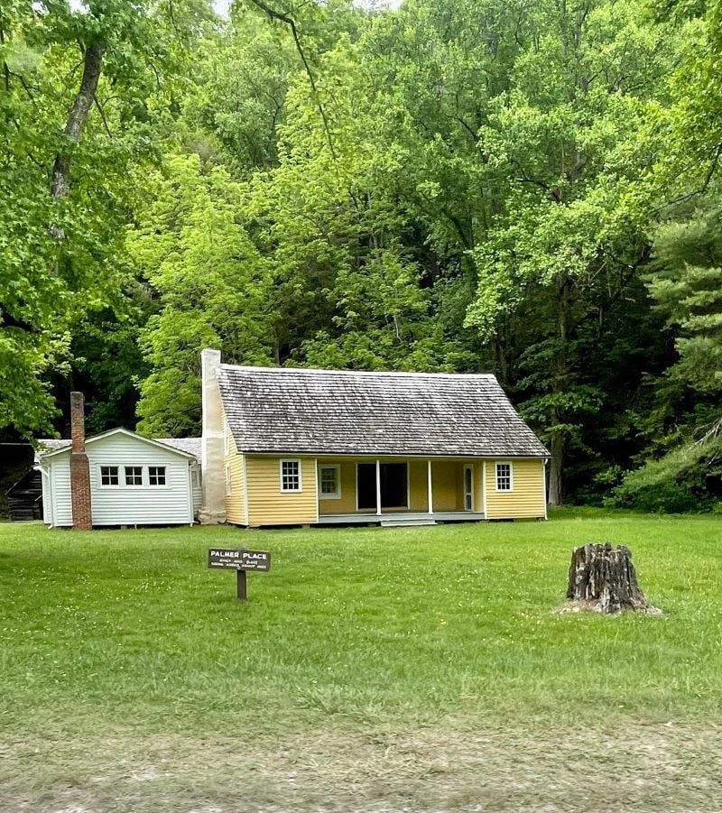 A quaint small house surrounded by lush greenery in Cataloochee Valley