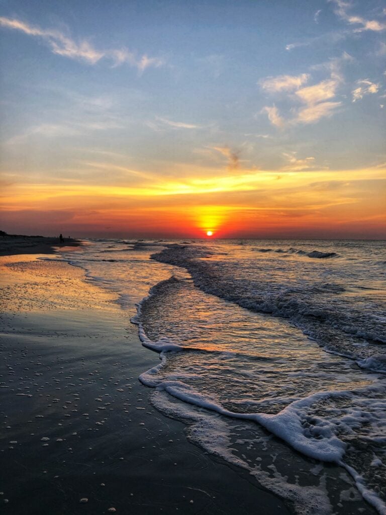 Sunset view of a serene Hilton Head beach with golden sand and gentle waves