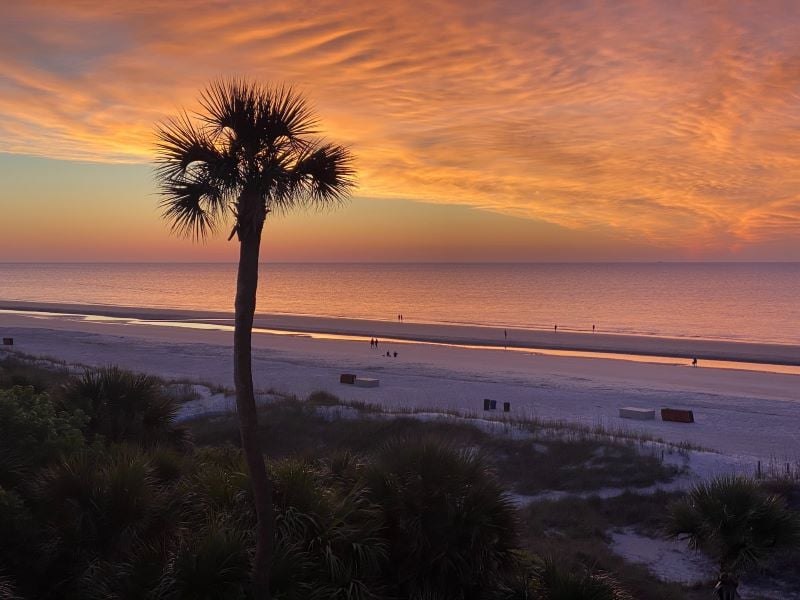 A serene sunset scene on Hilton Head Island, with the sun casting a warm glow over the water and beach