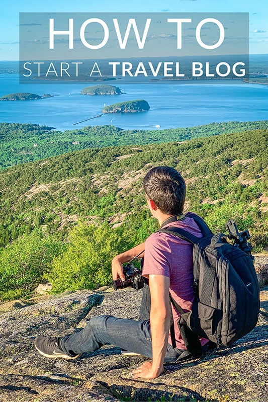 A man with backpack and camera, sitting on top of a rocky mountain looking down on nature