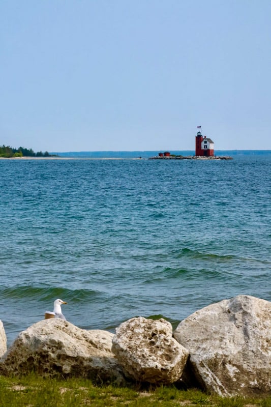 Discover Mackinac Island's charm, guided by its lighthouse to a serene summer paradise