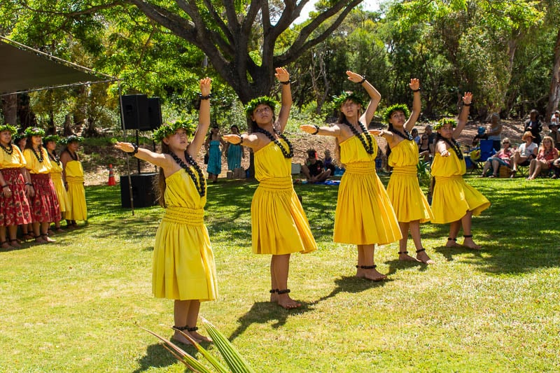 Group of young women in yellow dresses performing a vibrant dance routine