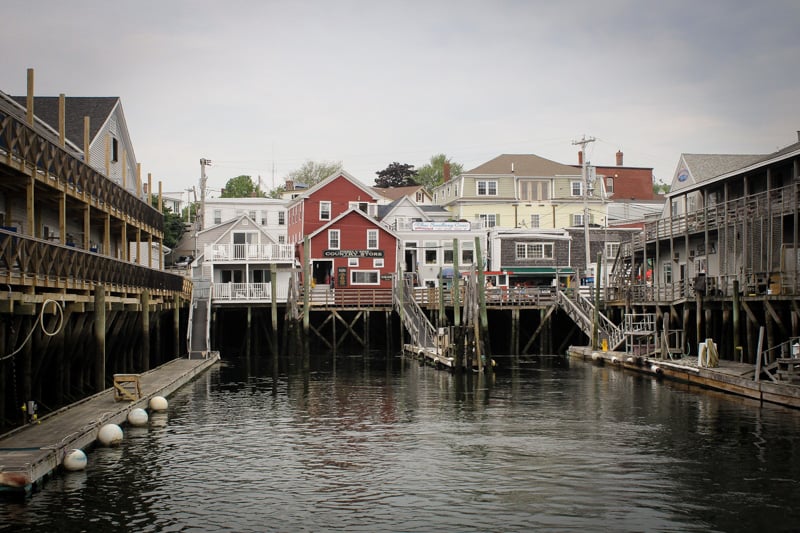 Boat docked at dock in front of row of houses in Portland, Maine