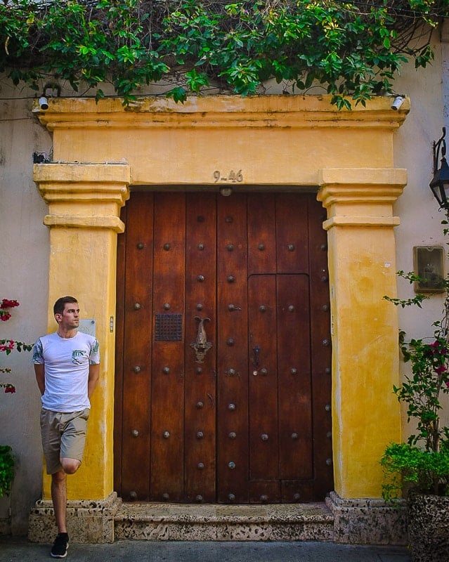 Jon standing in front of a large wooden door