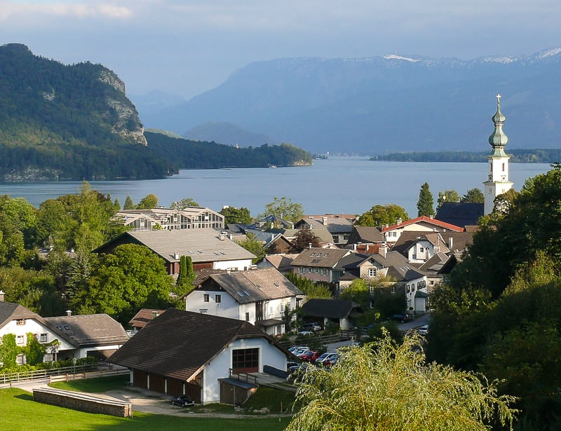 A picturesque town nestled amidst majestic mountains, with a charming church as its centerpiece