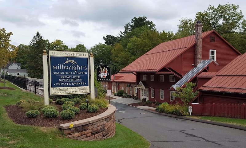 The exterior of a large red historic mill building, home to Millwright's Restaurant.