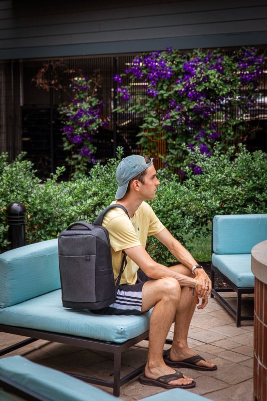 Jon sitting on a couch with a backpack