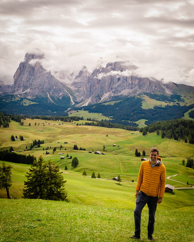 Jon standing in front of majestic mountain peaks, surrounded by nature's beauty and vastness